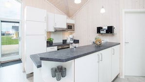 A modern kitchen with white cabinets, a black countertop, and a stainless steel oven. - Grobenbrode Kustenurlaub (Grossenbrode)