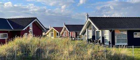 A row of houses with sloped roofs, likely in a coastal or rural area.