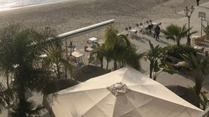 A beachside view with a clear sky, calm sea, and a few people walking. - Budello di Alassio, spacious apartment 30 meters from the beach, garage included (Alassio)