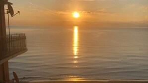 A sunset view from a balcony overlooking a beach with a clear sky. - Budello di Alassio, spacious apartment 30 meters from the beach, garage included (Alassio)