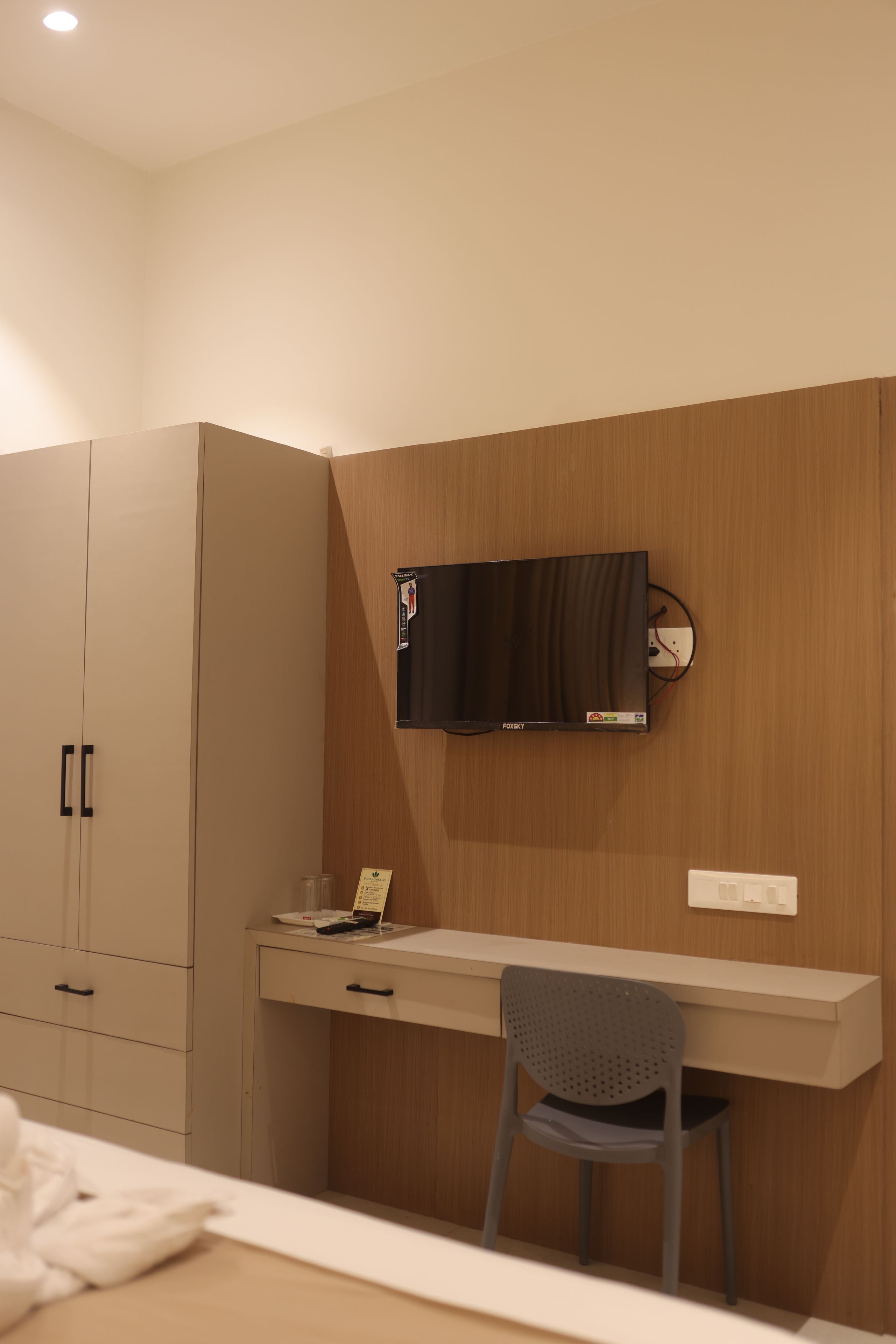 A bedroom with a bed, a desk, a chair, and a wardrobe.