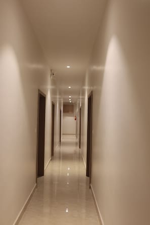 A long, narrow hallway with doors on both sides, leading to rooms. - Hotel Ashoka Inn Bilaspur (Bilaspur)