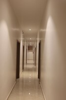 Un pasillo largo y estrecho con puertas a ambos lados, que conduce a habitaciones.