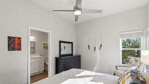 A bedroom with a bed, a ceiling fan, a dresser, a nightstand, and a window with a view. - Mountain, Canyon & Golf Course Views from all Windows in this corner 3 bedrm (Tucson)