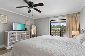 A bedroom with a bed, a ceiling fan, a television, a dresser, and a view of a balcony with outdoor scenery. - 🦩Book Me Baby! See You at the Bayou in Miramar Beach🦩 (Miramar Beach)