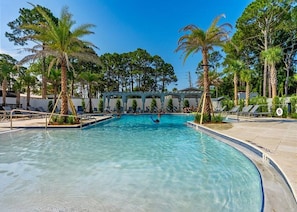 A swimming pool with palm trees, lounge chairs, and a clear blue sky. - 🦩Book Me Baby! See You at the Bayou in Miramar Beach🦩 (Miramar Beach)