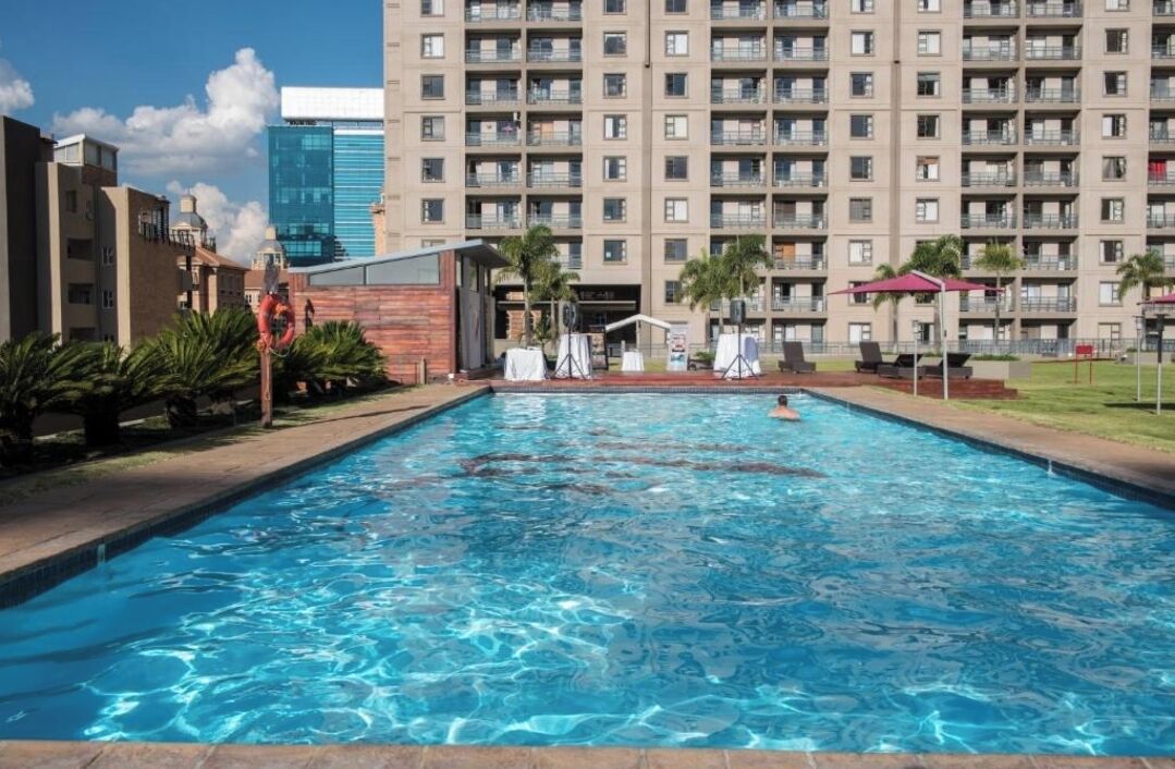 A swimming pool with a view of a high-rise building in the background.
