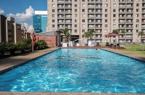Una piscina con vista a un edificio de gran altura al fondo.