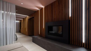 A modern interior with a built-in fireplace, wooden paneling, and a seating area. - Apartment mit Dachterrasse (Lübeck)