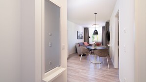 A modern interior with a dining area, a sofa, and a table with chairs. - Apartment mit Dachterrasse (Lübeck)