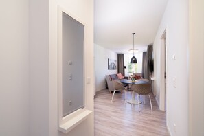 A modern interior with a dining area, a sofa, and a table with chairs. - Apartment mit Dachterrasse (Lübeck)