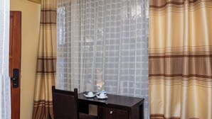 Una habitación con un escritorio de madera, una silla y un sofá azul.