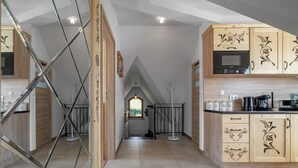 A modern kitchen with wooden cabinetry, a Bosch microwave, and a coffee maker. - RentPlanet - Apartament Kierpcówka (Kościelisko)