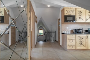 Una cocina moderna con armarios de madera, un microondas Bosch y una cafetera.