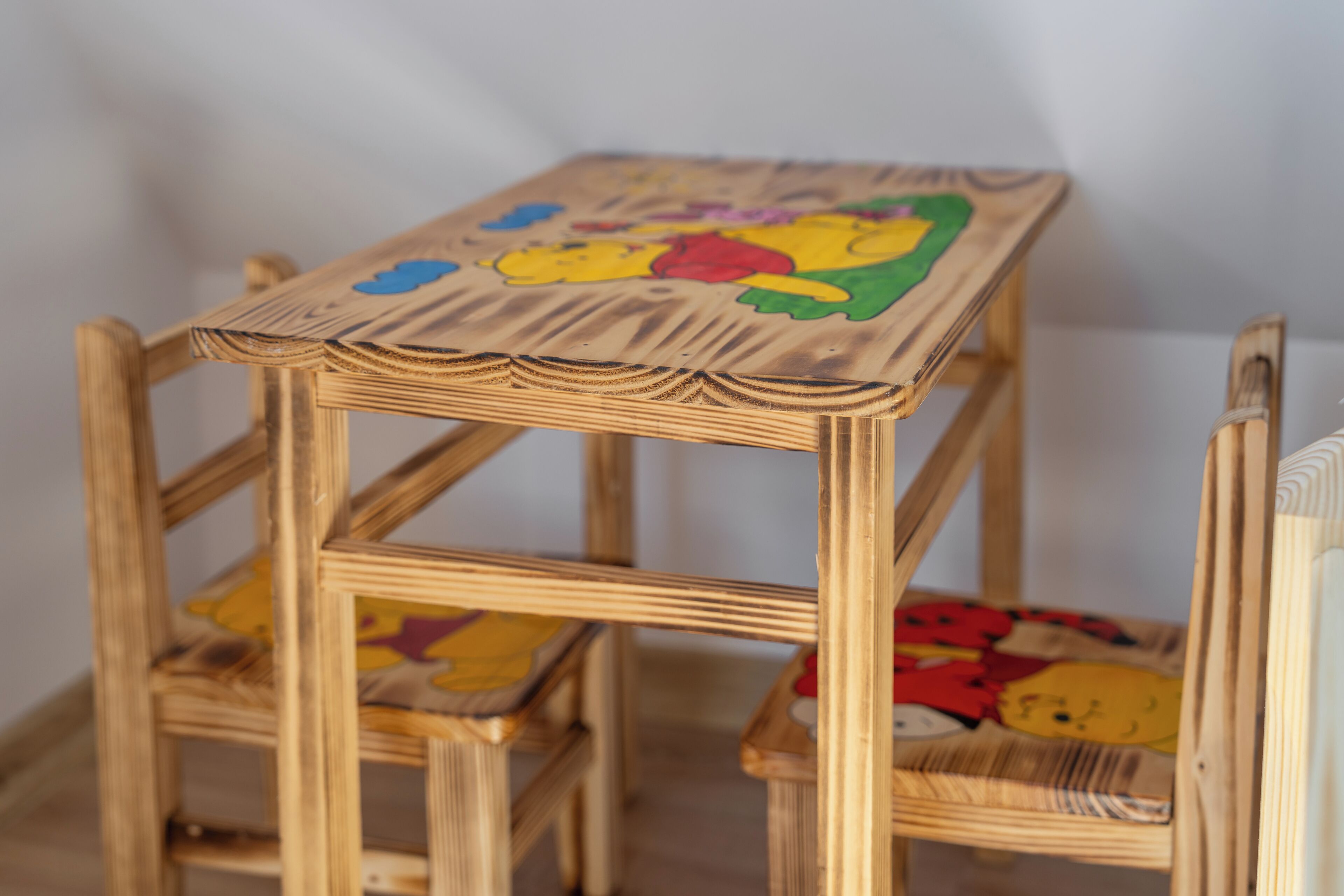 Una silla de madera con un diseño colorido en el asiento.