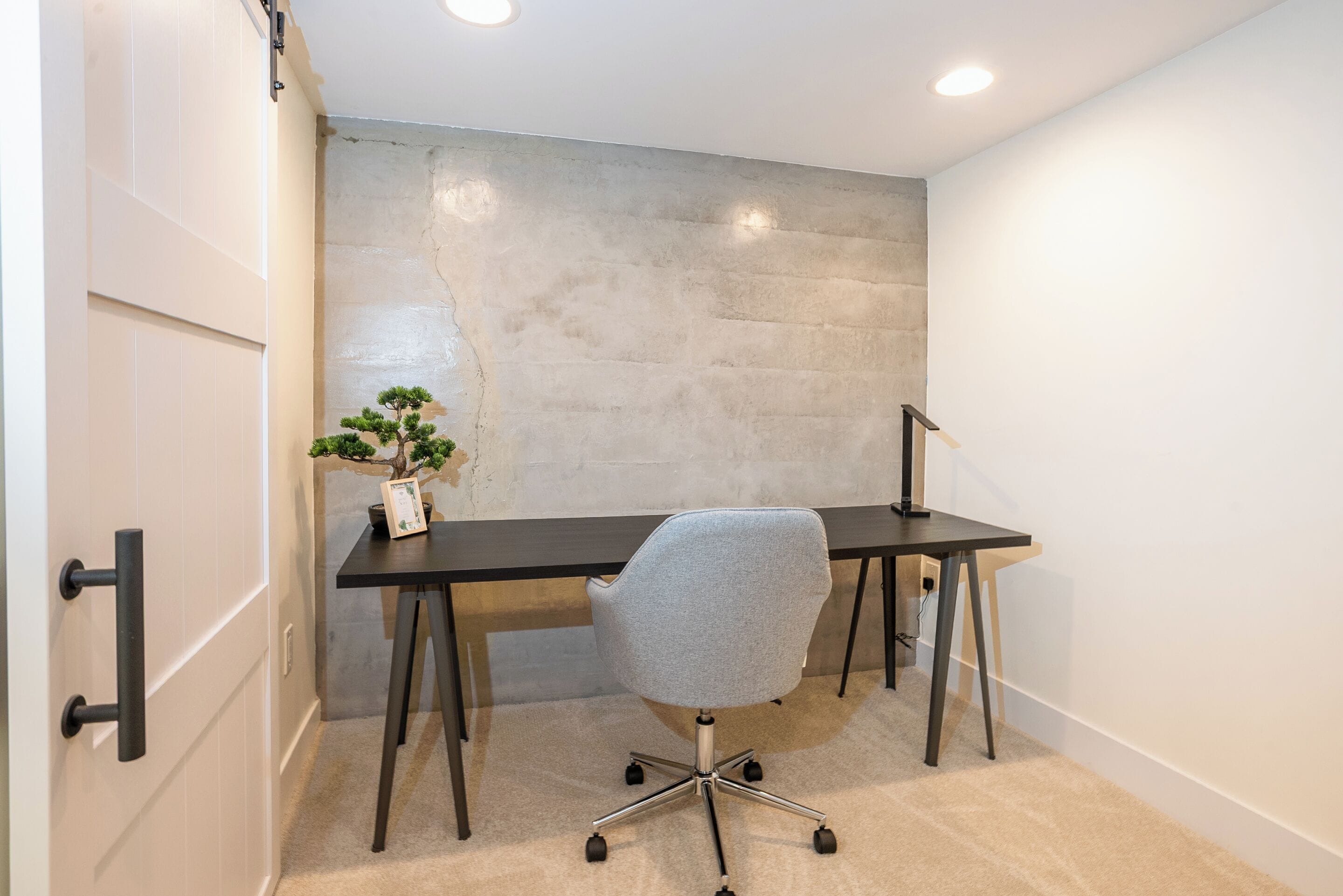 Un espace de bureau moderne comprenant un bureau, une chaise et une plante en pot.
