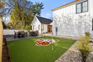A house with a lawn, a patio with chairs, and a door. - CUSTOM FALCON PUTTING GREEN and Luxury combined to create your DREAM stay here in the heart of Bowling Green! (Bowling Green)