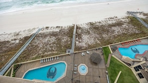 A beachside resort with a swimming pool, lounge chairs, and a boardwalk. - Phoenix Iv 4122 1 Bedroom Condo (Orange Beach)