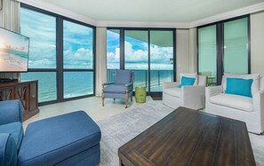 Ein geräumiger Balkon mit Blick auf den Ozean, ausgestattet mit einer Couch, Sesseln und einem Couchtisch.