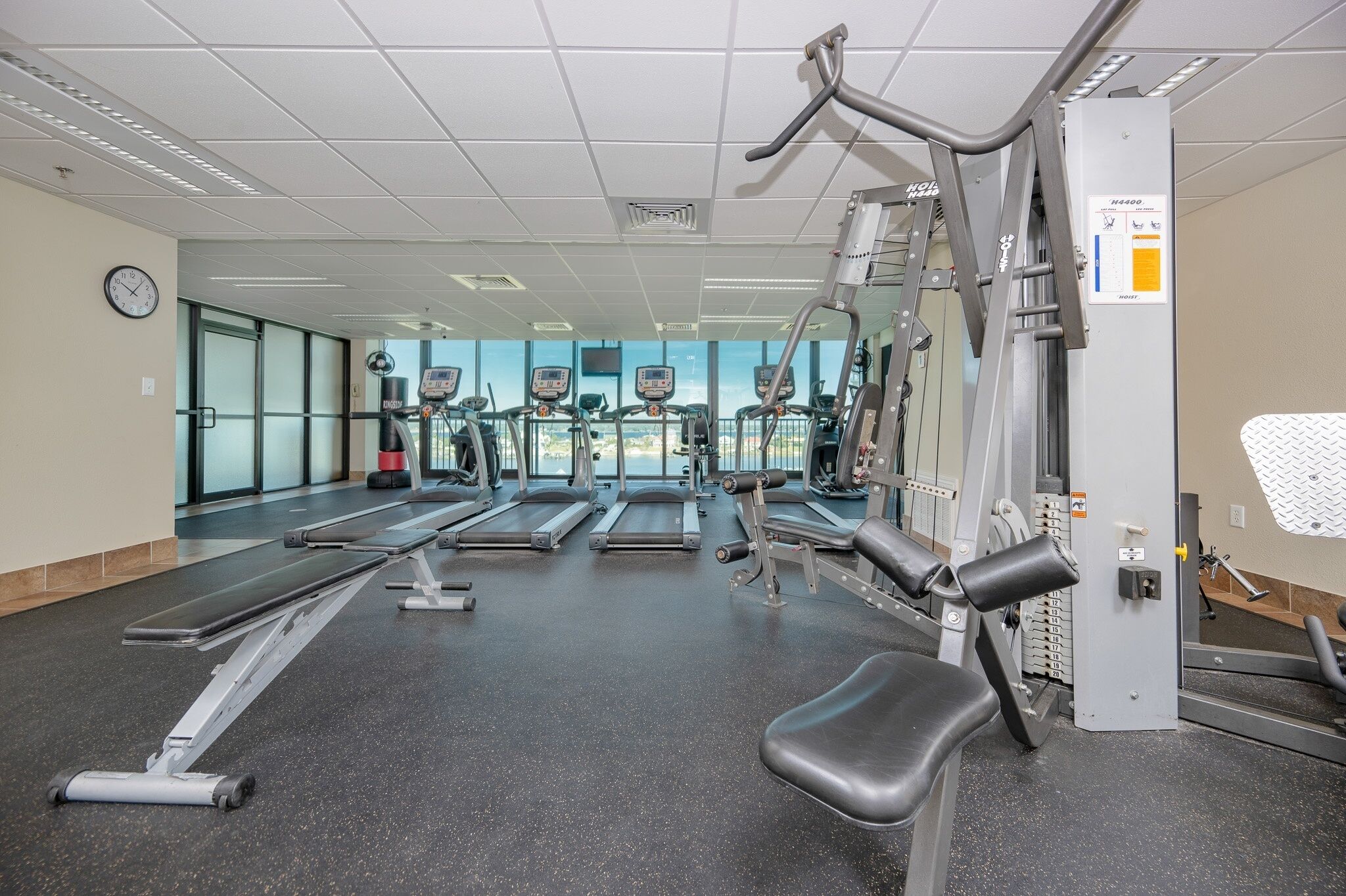 A gym with treadmills, elliptical machines, and weightlifting equipment.