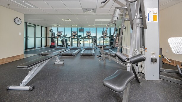 A gym with treadmills, elliptical machines, and weightlifting equipment. - Phoenix Ix 1202 2 Bedroom Condo (Orange Beach)