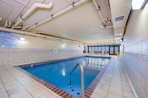 An indoor swimming pool with clear water, a metal ladder, and tiled walls. - Phoenix Iv 4104 2 Bedroom Condo (Orange Beach)