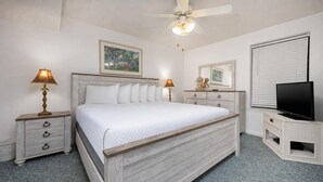 A bedroom with a bed, two bedside tables, a ceiling fan, a television, and artwork on the walls. - Phoenix Iv 4062 1 Bedroom Condo (Orange Beach)