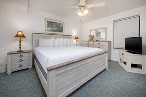A bedroom with a bed, two bedside tables, a ceiling fan, a television, and artwork on the walls. - Phoenix Iv 4062 1 Bedroom Condo (Orange Beach)