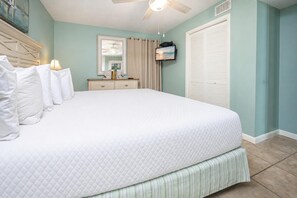 A bedroom with a large bed, a dresser, a television, and a ceiling fan. - Phoenix Iv 4022 1 Bedroom Condo (Orange Beach)