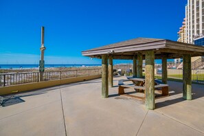 A beachside pavilion with a view of the ocean and a tall monument. - Phoenix Iv 4022 1 Bedroom Condo (Orange Beach)