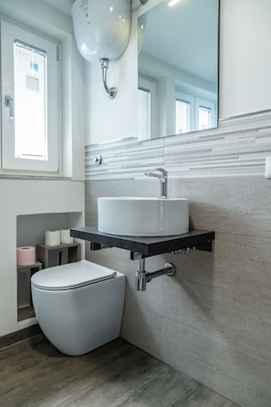 A modern bathroom with a toilet, sink, and shower. - Circo Massimo Room (Roma)