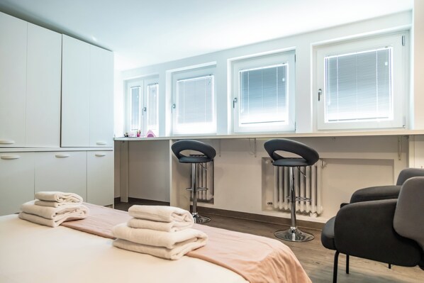A hotel room with a bed, a radiator, two chairs, and a window with blinds. - Circo Massimo Room (Roma)
