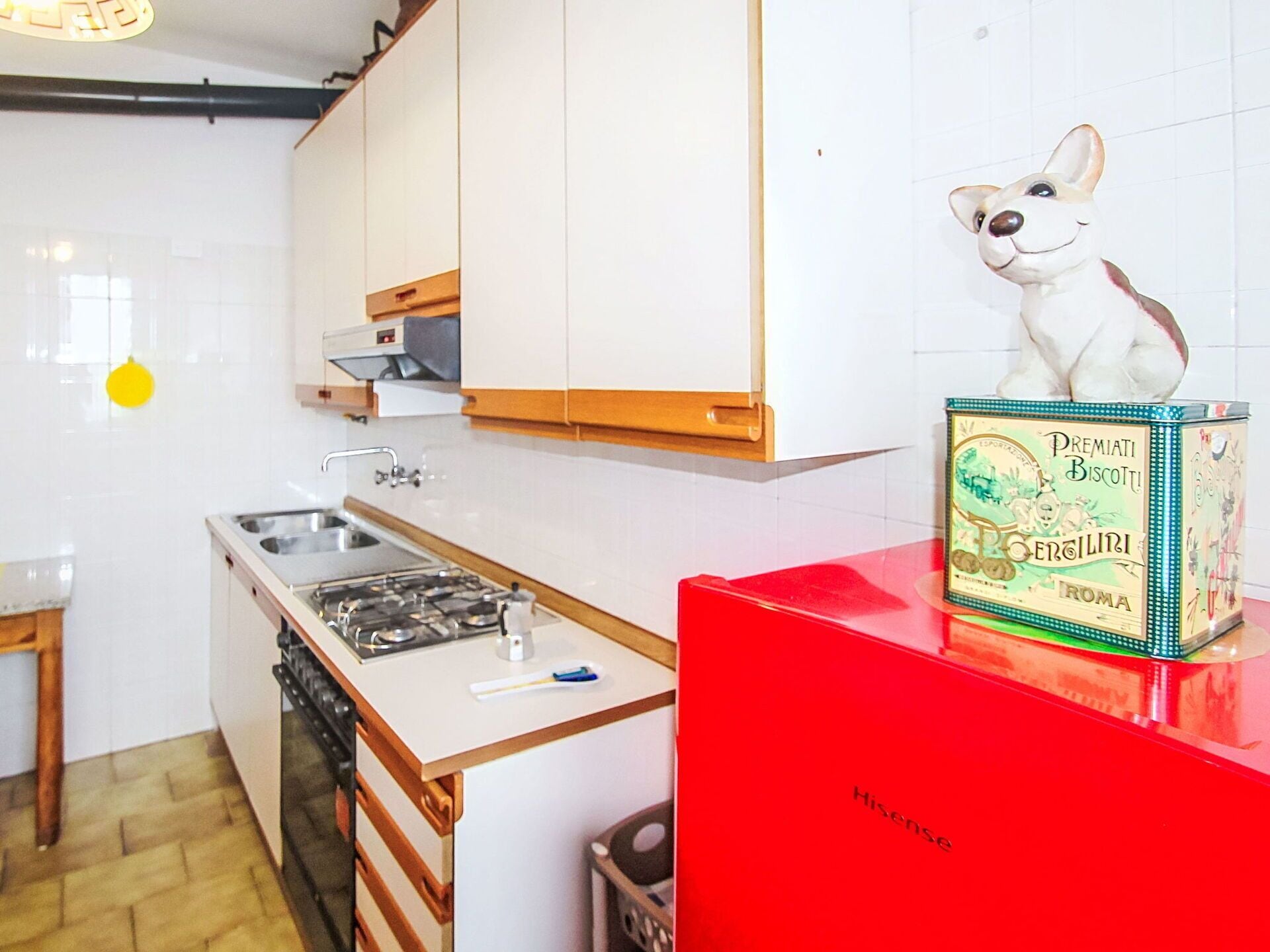 Una cocina compacta con estufa a gas, lavamanos y armarios de madera.