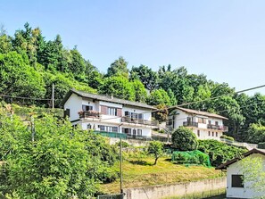 Ein Wohngebiet an einem Hang mit mehrstöckigen Gebäuden, einer sichtbaren Treppe und üppiger Vegetation.