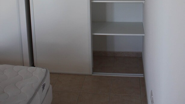 A bedroom with a bed, a wardrobe, and a built-in closet with shelves. - Breathtaking view of Lake Serre-Ponçon (Chorges)