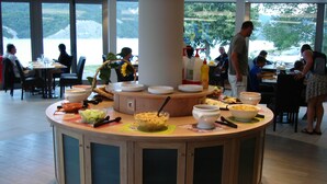 A buffet setup with various dishes and a central serving area. - Breathtaking view of Lake Serre-Ponçon (Chorges)