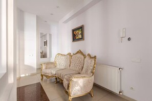 Ein Zimmer mit einer großen, verzierten Couch und einer Heizung.