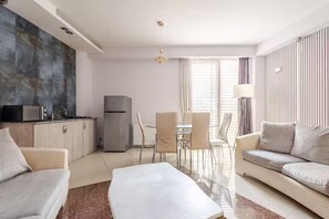 Ein modernes Wohnzimmer mit einer Couch, einem Couchtisch und einem Essbereich mit Stühlen und einem Tisch.