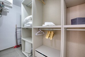 A hotel room with a white wardrobe, a bed with white bedding, and a small table with a black object on it. - Xag ra Apartment With Sea Views Balcony Gozo (Xaghra)