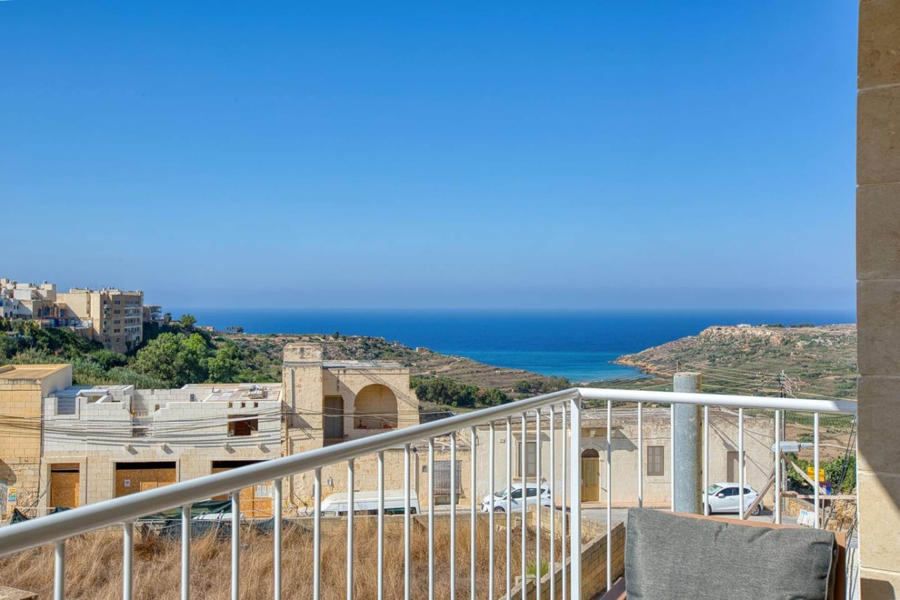Un balcon avec vue sur la mer et les bâtiments.