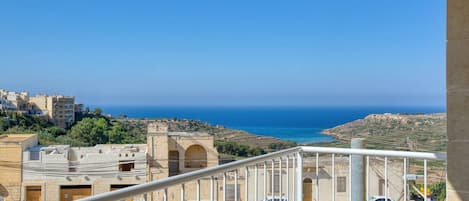 Un balcon avec vue sur la mer et les bâtiments.