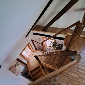 Eine Holztreppe mit Blick auf einen Raum darunter.