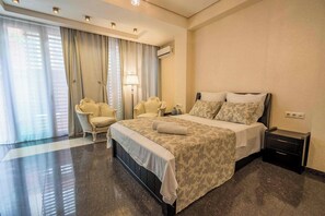 Habitación de hotel con cama, una silla, una mesita de noche y una lámpara.