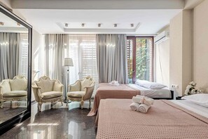 A hotel room with a large mirror, two ornate chairs, a bed with a pink bedspread, and a window with curtains. - Beautiful 3-bedroom apartment with AC in vibrant Tbilisi (tbilisi)