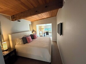 A bedroom with a bed, bedside tables, a lamp, a TV, and a window. - Waterfront 3 bed, 2 bath lake-house on Cedar Creek (Mabank)