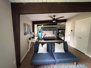 A room with a blue sofa, a ceiling fan, a bed, and a wardrobe. - Waterfront 3 bed, 2 bath lake-house on Cedar Creek (Mabank)