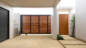 A modern interior with a concrete floor, a wooden sliding door, a wooden door, and a small plant. - Botanica Pru Jampa New 3BR Pool Villa (ตำบล เทพกระษัตรี)