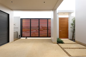 Ein modernes Interieur mit Betonboden, einer Holztür zum Verschieben, einer Holztür und einer kleinen Pflanze.
