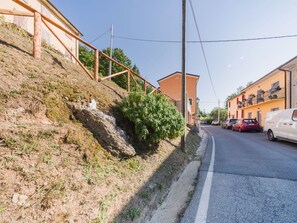 Eine Wohnstraße mit Häusern an beiden Seiten, einem klaren Himmel und einer Straße, an der Autos geparkt sind.