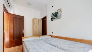 Una camera da letto con un letto di legno, un armadio e un quadro appeso al muro.